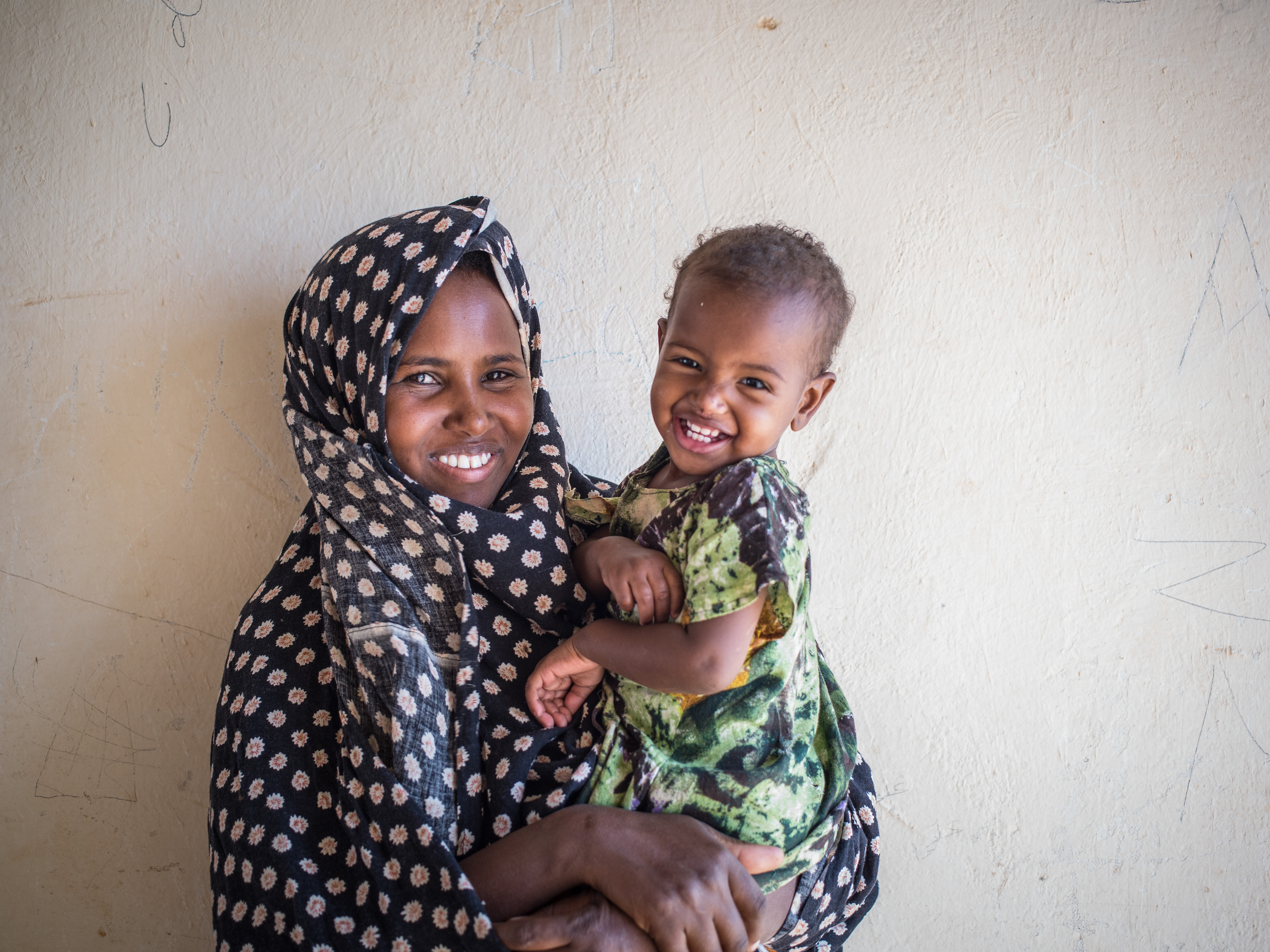 A malnourished toddler in his mother's arms can be examined thanks to her donation