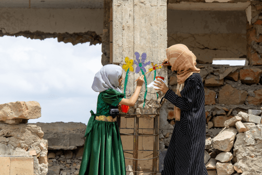 Kinder im Jemen malen hoffnungsvolle Blumen an eine von Bomben zerstörte Schule.