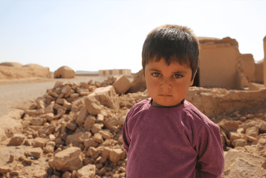 Jawid, 4 Jahr, steht vor den Trümmern, die durch das Erdbeben in Afghanistan entstanden sind.